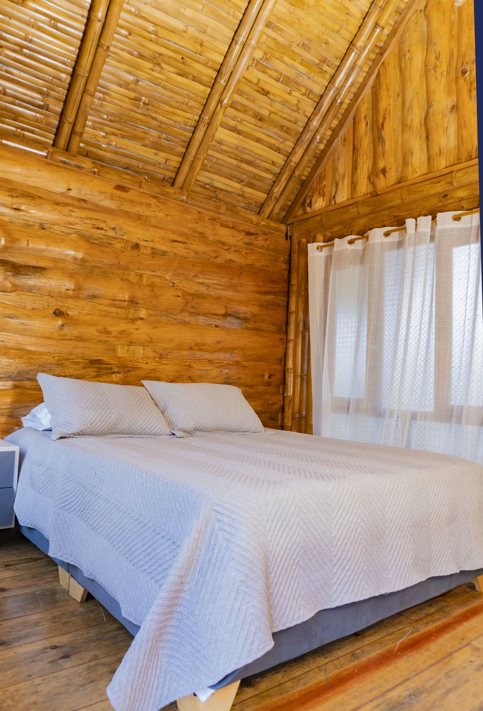Habitación de cabaña de madera con cama tendida