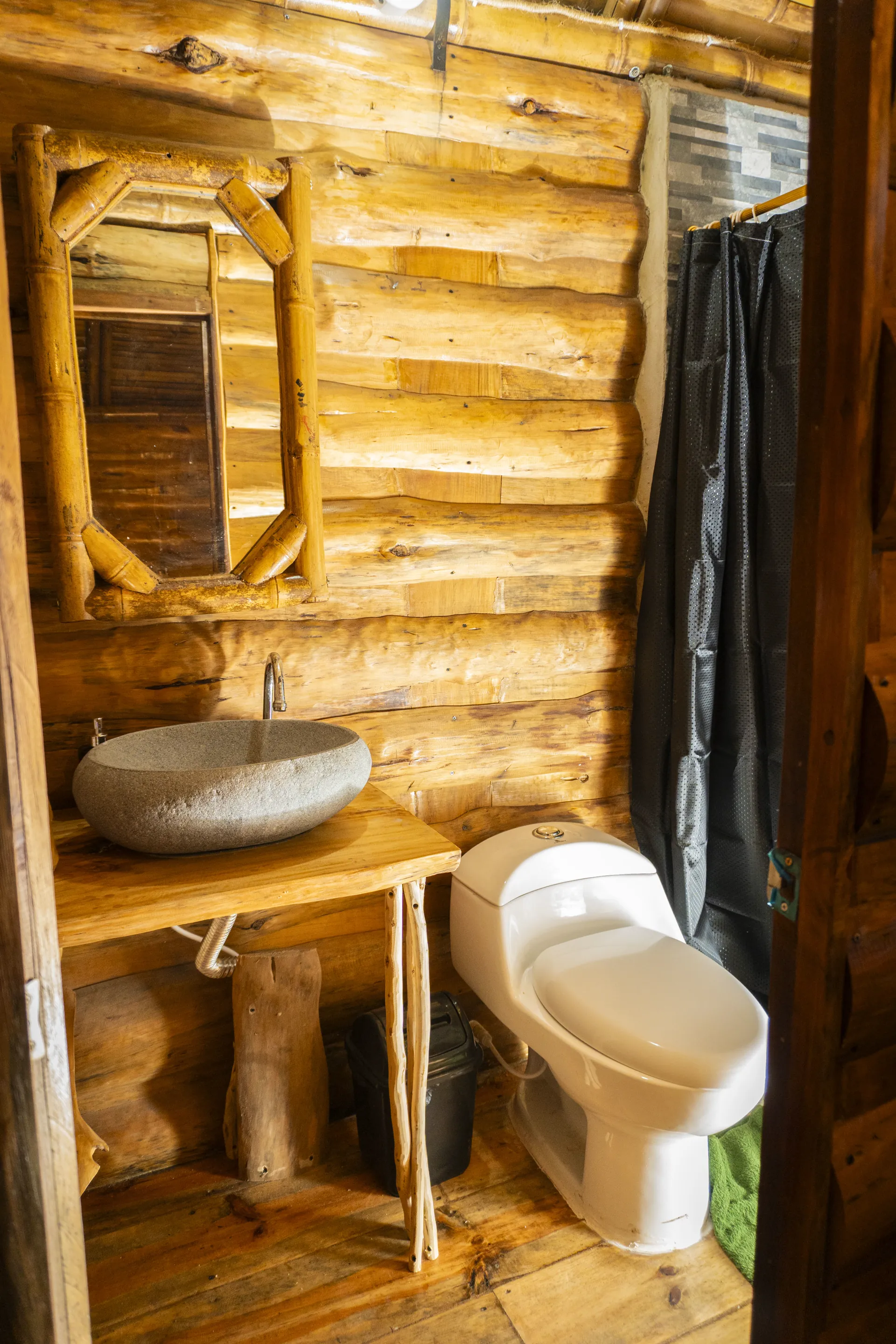 Baño de cabaña con lavamanos de piedra y sanitario
