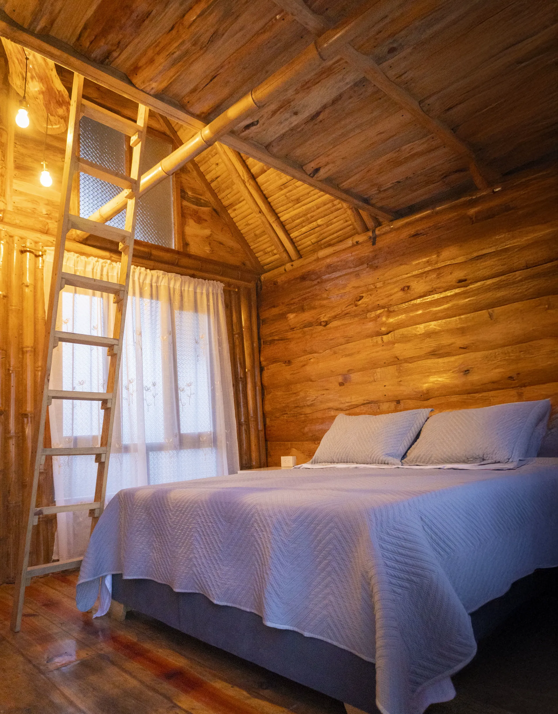 Habitación de cabaña de madera con cama y ventana iluminada