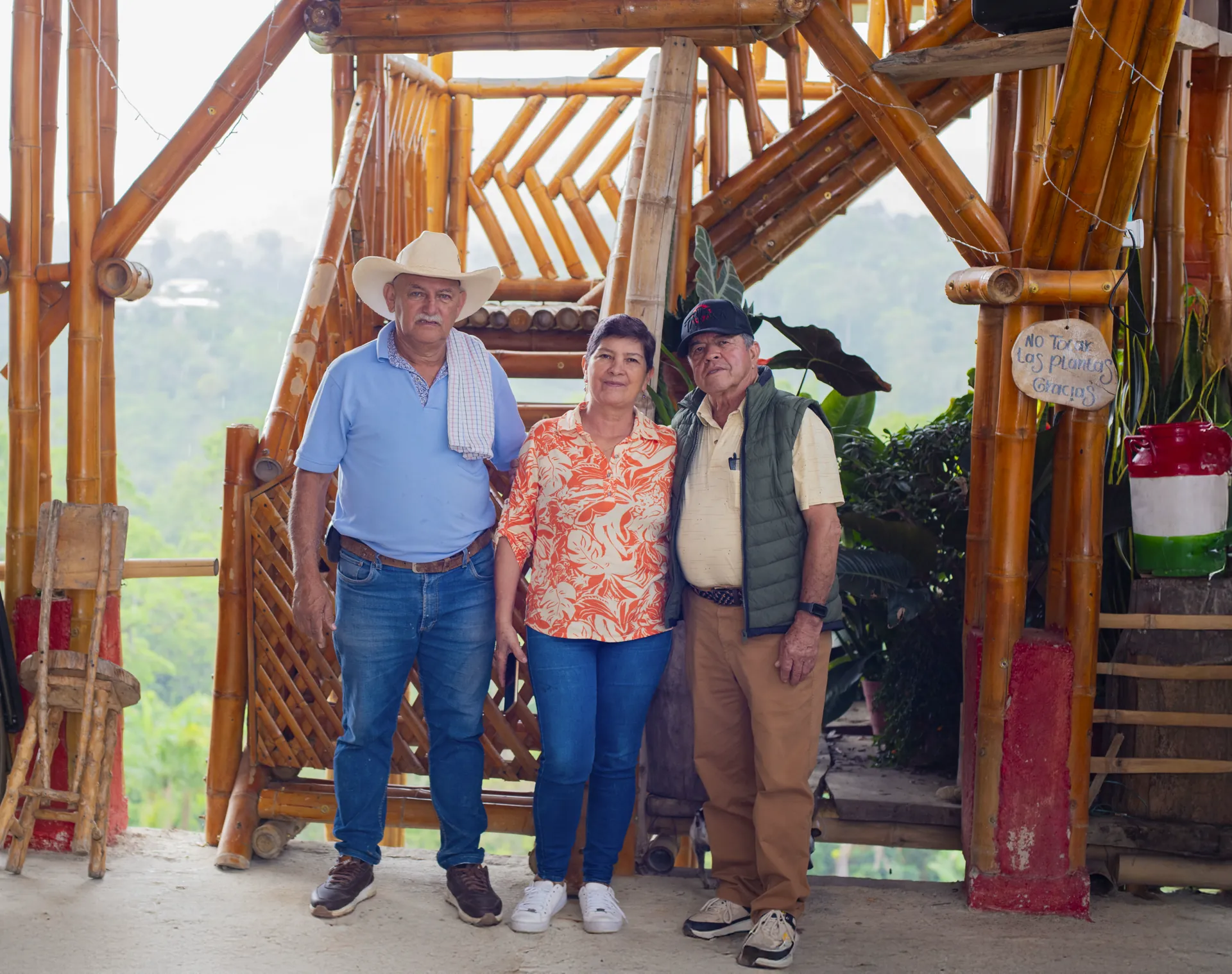 Grupo de personas reunido en una estructura de madera entre árboles